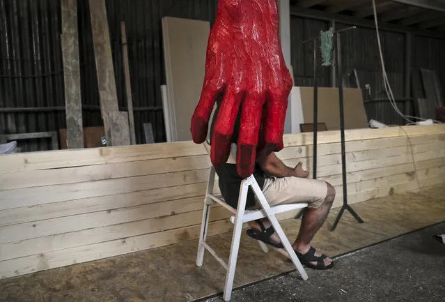 In this photo taken on Wednesday, July 19, 2017, artist Catalin Badarau is obscured by one of his works during an interview with the Associated Press in Bucharest, Romania. An art exhibition showcasing 11 sculptures, which aims to remind visitors about the horrors that took place at Southern Romania's Pitesti Prison from 1949 to 1951, where communists tortured and killed political prisoners in a gruesome re-education program, went on display Friday, July 21, 2017. (Photo by Vadim Ghirda/AP Photo)