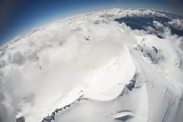 Fred Fugen and Vincent Reffet seen jumping at 33,000 feet (10 km) above the Mont Blanc, French Alps on May 31, 2014. Fearless skydivers jump from an altitude of 10,000 meters above the largest mountain in Europe. Frederic Fugen, 34, and Vincent Reffet, 29, leapt from a plane in the freezing skies above Mont-Blanc in the French Alps. The jump is from such a height the pictures show the curvature of the earth. (Photo by Dominique Daher/Barcroft Media)