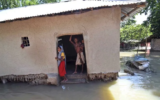 Villagers stand inside their house destroyed by floodwaters at Katihar district, in the eastern Indian state of Bihar, Saturday, August 19, 2017. Heavy monsoon rains have unleashed landslides and floods that killed hundreds of people in recent days and displaced millions more across northern India, southern Nepal and Bangladesh. Deadly landslides and flooding are common across South Asia during the summer monsoon season that stretches from June to September. (Photo by Aftab Alam Siddiqui/AP Photo)