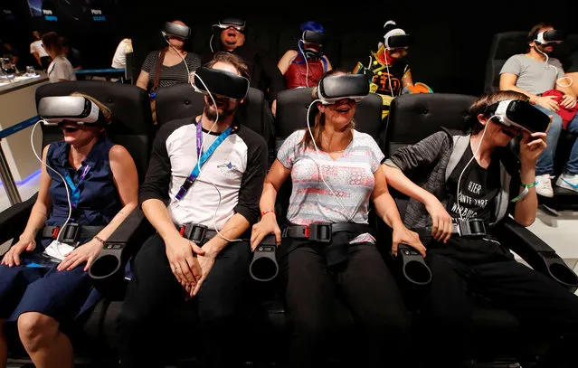 Gamers enjoy a virtual ride in a roller coaster, while wearing virtual reality goggles at the world's largest computer games fair, Gamescom, in Cologne, Germany August 23, 2017. (Photo by Wolfgang Rattay/Reuters)