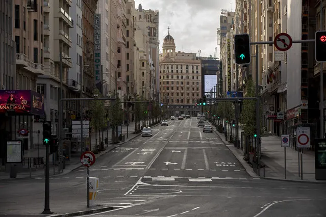 Cars drive along an empty Gran Via Street on March 15, 2020 in Madrid, Spain. The cases in Madrid are 2,807 people infected of Coronavirus and 133 deaths. The Spanish government has declared a state of emergency and is poised to put the country under lockdown to combat the virus. (Photo by Pablo Blazquez Dominguez/Getty Images)