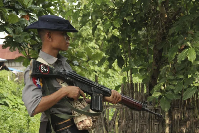 A Myanmar police officer stands watch as journalists arrive in Shwe Zar village in the suburb of Maungdaw town, northern Rakhine state of Myanmar, on Wednesday, September 6, 2017. Myanmar leader Aung San Suu Kyi's top security adviser sought to counter the storm of criticism the government is facing from around the world over alleged army abuses against ethnic minority Rohingya, asserting that security forces were acting with restraint in pursuing “terrorists”. (Photo by AP Photo)