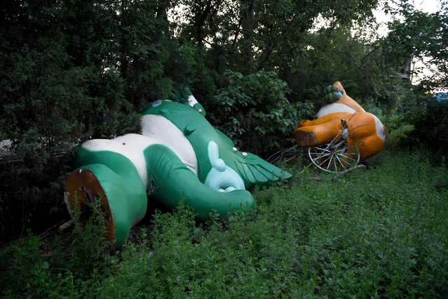 Nini, left, and Yingying, two of the five mascots for the 2008 Beijing Olympic Games, are seen lying among trees behind an abandoned, never-completed mall in Beijing. The fallen mascots are a reminder of the high costs of hosting the event. Their derelict state reflects the challenges that China has faced in finding new uses for its Olympic investments, with many venues falling into disrepair and some construction projects left incomplete. (Photo by Greg Baker/AFP Photo)