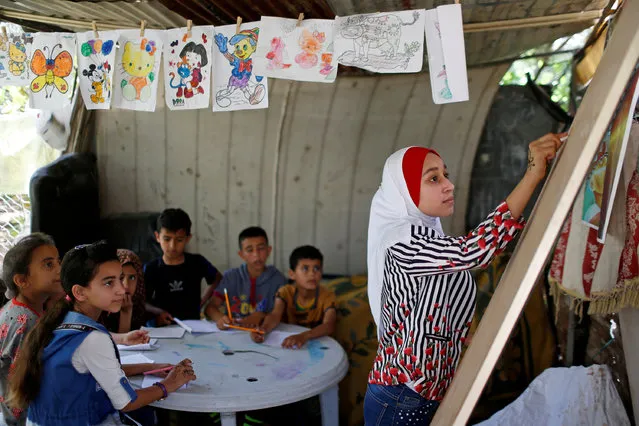A Palestinian school girl Fajr Hmaid, 13, teaches her neighbours' children an Arabic language lesson as schools are shut due to the coronavirus disease (COVID-19) restrictions, at her family house in Gaza, May 19, 2020. (Photo by Mohammed Salem/Reuters)