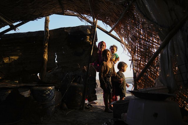 Children stand in front of their traditional reed house of the Chibayish marshes in Nasiriyah, Iraq, Friday, September 6. 2024. Deep within Iraq's celebrated marsh lands, conservationists are sounding alarm bells and issuing a stark warning: Without quick action, the UNESCO protected site could all but wither away. (Phoot by Hadi Mizban/AP Photo)