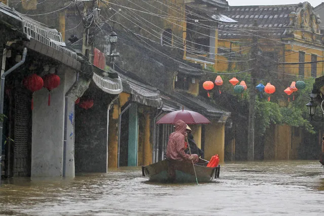 People ride a boat in flooded street in Hoi An, Vietnam, Monday, November 6, 2017. (Photo by Hau Dinh/AP Photo)