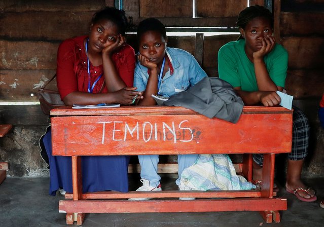 Internally displaced Congolese witnesses sit inside the voting station at the Kanyaruchinya polling centre, during the Presidential election, at the Kanyaruchinya site for displaced people, in Nyiragongo territory, near Goma in North Kivu province of the Democratic Republic of Congo on December 20, 2023. (Photo by Thomas Mukoya/Reuters)