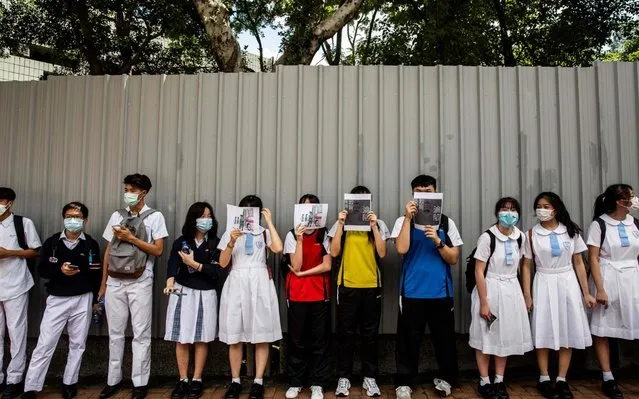 School students hold signs during a pro-democracy protests near their school in Hong Kong on June 12, 2020. (Photo by Isaac Lawrence/AFP Photo)