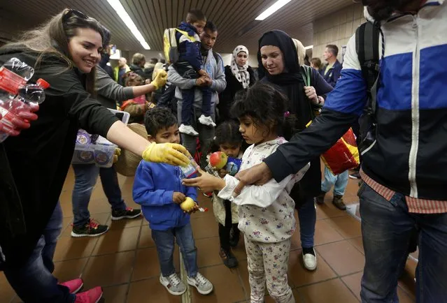 Wellwishers offer soft drinks to migrant children from Syria after they arrived at the main railway station in Dortmund, Germany September 13, 2015. (Photo by Ina Fassbender/Reuters)
