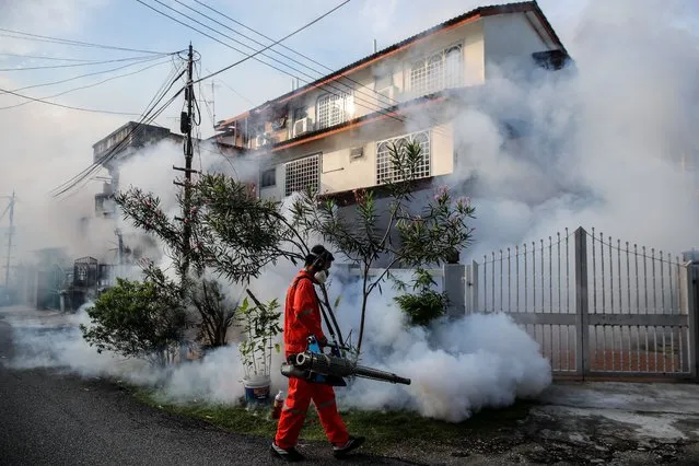 A health worker sprays an area to prevent dengue fever infections, in Kuala Lumpur, Malaysia, 28 July 2022. Dengue fever is reportedly caused by a specific type of mosquito, the Aedes mosquito, that bites only during daytime, especially during sunrise and sunset. (Photo by Fazry Ismail/EPA/EFE)