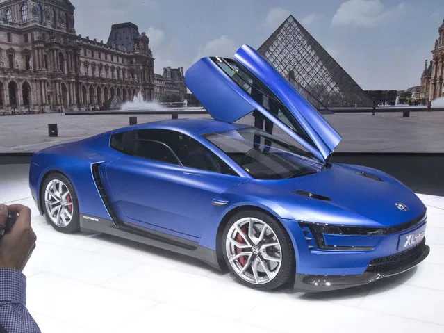 A journalist take a pictures of the Volkswagen XL Sport car during the press day at the Motor Show in Paris, France, Thursday, October 2, 2014. (Photo by Michel Euler/AP Photo)