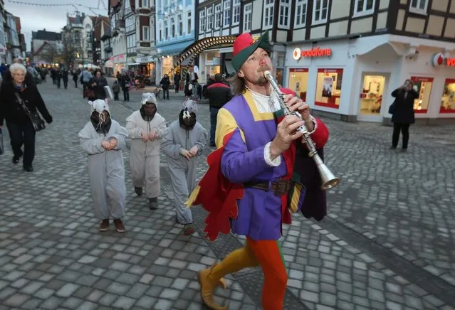 The Pied Piper of Hamelin, actually city tourism employee Michael Boyer, leads local children dressed as rats through a pedestrian shopping street on November 19, 2012 in Hameln, Germany. The Pied Piper (in German: Der Rattenfaenger), is one of the many stories featured in the collection of fairy tales collected by the Grimm brothers, and the 200th anniversary of the first publication of the stories will take place this coming December 20th. Boyer, a U.S. citizen who has lived in Hameln for 15 years, and city children regularly perform a reenactment of the Pied Piper tale throughout the summer months. The Grimm brothers collected their stories from oral traditions in the region between Frankfurt and Bremen in the early 19th century, and the works include such global classics as Sleeping Beauty, Little Red Riding Hood, Rapunzel, Cinderella and Hansel and Gretel.  (Photo by Sean Gallup)