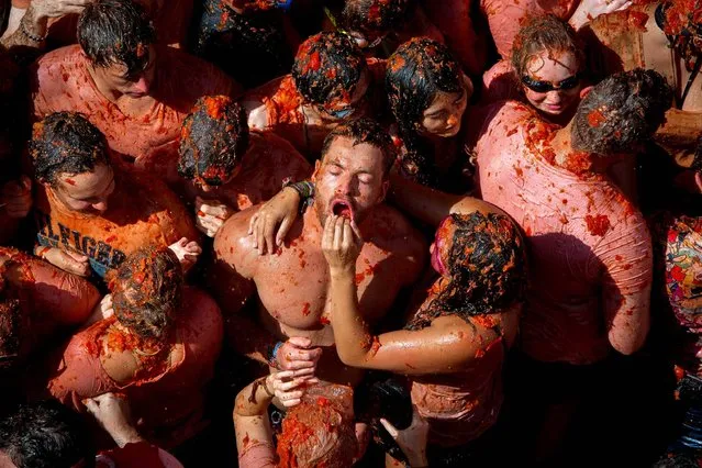 Revellers pelt oneanother with tomato pulp during the annual “Tomatina” festivities in the village of Bunol, near Valencia on August 31, 2016. Today at the annual Tomatina fiesta 160 tonnes of ripe tomatoes were offloaded from trucks into a crowd of 22,000 half-naked revellers who packed the streets of Bunol for an hour-long battle. (Photo by Biel Alino/AFP Photo)