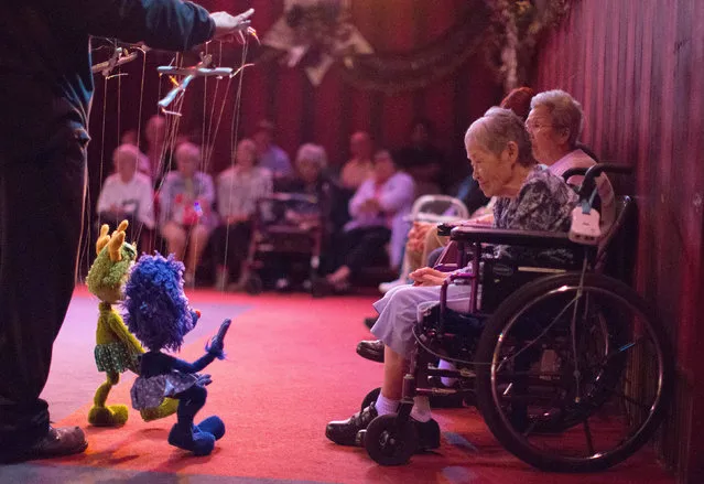 Jean Matsusaka, 84, smiles as a marionette waves to her during a performance at the Bob Baker Marionette Theater in Los Angeles, California October 17, 2014. The playhouse started in 1960, has 2,000 marionettes and is the oldest continually running marionette theater in the U.S. It was recently bought by a developer who wants to turn the historic landmark into a 104-unit apartment complex. (Photo by Lucy Nicholson/Reuters)