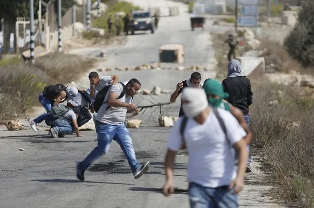 Palestinian protesters run for cover during clashes with Israeli troops near the Jewish settlement of Bet El, near the occupied West Bank city of Ramallah October 5, 2015. (Photo by Mohamad Torokman/Reuters)