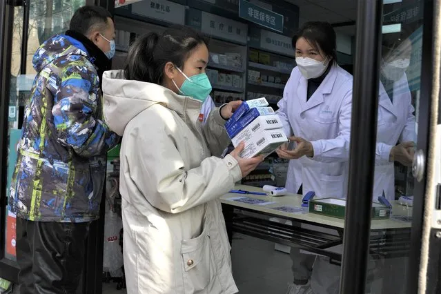 A resident carries away medicine bought at a pharmacy in Beijing, Friday, December 9, 2022. (Photo by Ng Han Guan/AP Photo)