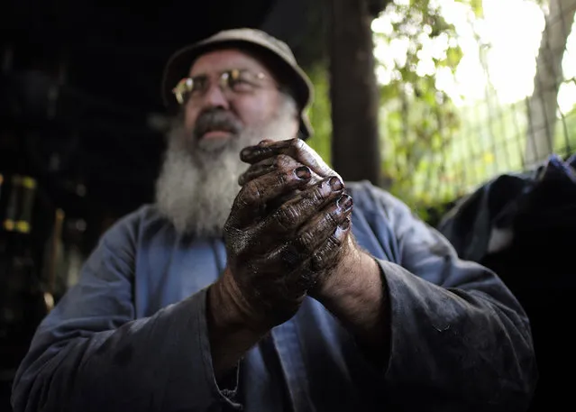 Gary Pallister cleans grime off his hands after a day's work on the Puffing Billy Railway at Belgrave station near Melbourne, October 17, 2014. (Photo by Jason Reed/Reuters)