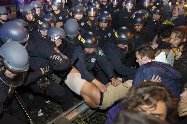 Police grab a protester during a demonstration in Oakland, California, following the grand jury decision in the shooting of Michael Brown in Ferguson, Missouri, November 24, 2014. Protests were also staged in New York, Chicago, Washington, D.C. and Seattle over the case that has highlighted long-standing racial tensions not just in predominantly black Ferguson but across the United States. (Photo by Elijah Nouvelage/Reuters)