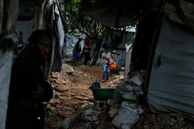 A woman carries her baby at a camp for displaced people while Hurricane Matthew approaches in Port-au-Prince, Haiti October 3, 2016. (Photo by Carlos Garcia Rawlins/Reuters)