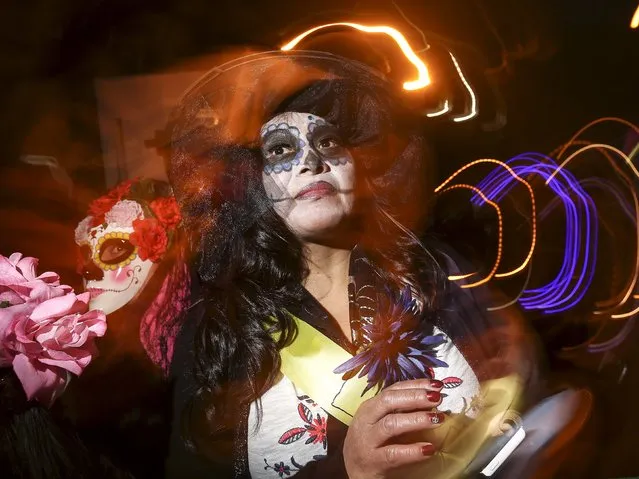 A reveler dressed in a "Dia de Muertos" or "Day of the Dead" theme poses for a photo while taking part in the Greenwich Village Halloween Parade in the Manhattan borough of New York, October 31, 2015. (Photo by Carlo Allegri/Reuters)