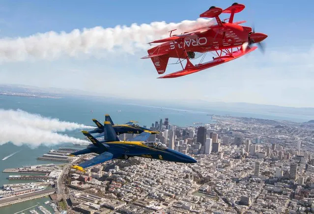 The US Navy Blue Angels numbers 5 and 6 fly below Sean Tucker (above) as he pilots the Oracle Challenger III over San Francisco, California as part of a practice run for Fleet Week on October 6, 2016. (Photo by Josh Edelson/AFP Photo)