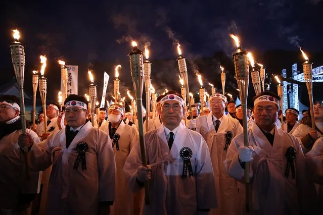 South Koreans carry torches as they march on the street during a re-enactment of the March First Independence Movement against Japanese during the 104th Independence Movement Day ceremony on February 28, 2023 in Cheonan, South Korea.South Koreans celebrate the public holiday marking the 1919 civilian uprising against Japanese rule, which colonized the Korean peninsula from 1910-1945. (Photo by Chung Sung-Jun/Getty Images)