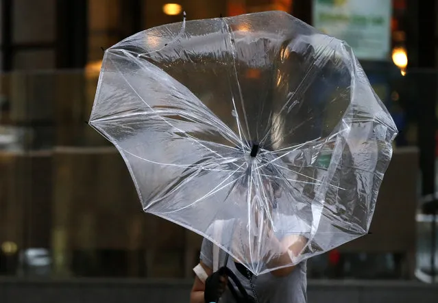 A woman struggles with an umbrella in strong winds and rain caused by Typhoon Halong in Tokyo August 10, 2014. (Photo by Toru Hanai/Reuters)