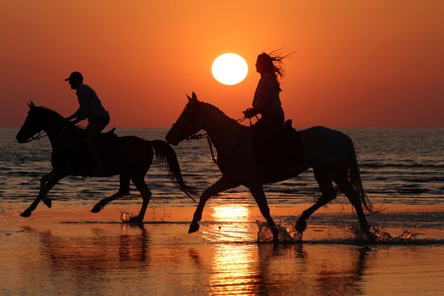 People ride horses on a beach during sunset as temperatures rise near Durres, Albania, on July 14, 2025. (Photo by Florion Goga/Reuters)