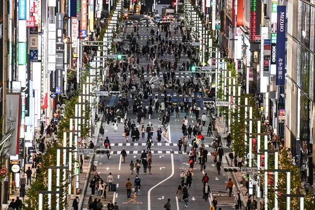 People walk on a street in Tokyo's Ginza area on November 23, 2020. (Photo by Charly Triballeau/AFP Photo)