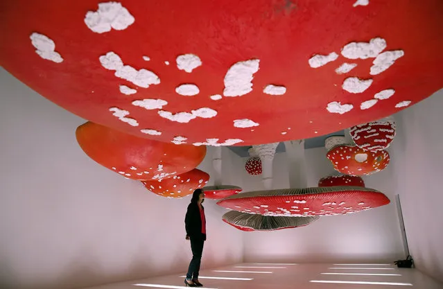 A woman looks at the installation “Upside Down Mushroom Room” by Carsten Holler, part of the Design Week, at the Prada's foundation, in Milan, Italy, Wednesday, April 18, 2018. Dutch architect Rem Koolhaas says the 10-story tower he designed for the Prada Foundation is meant to reveal the interaction between art and architecture. (Photo by Antonio Calanni/AP Photo)