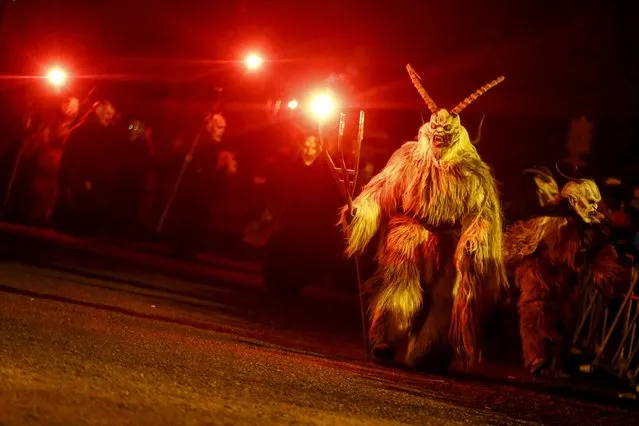 A man dressed in a traditional Perchten costume and mask performs during a Perchten festival in the western Austrian village of Kappl, November 13, 2015. (Photo by Dominic Ebenbichler/Reuters)