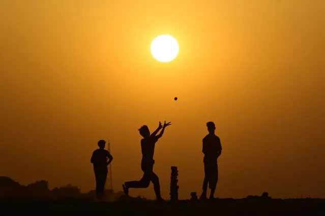 Boys play cricket on the banks of river Ganges in Prayagraj on April 4, 2023. (Photo by Sanjay Kanojia/AFP Photo)