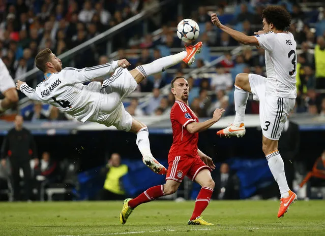 Real Madrid's Sergio Ramos jumps to block a pass from Bayern Munich's Frank Ribery as Pepe watches during their Champions League semi-final first leg soccer match at Santiago Bernabeu stadium in Madrid April 23, 2014. (Photo by Paul Hanna/Reuters)