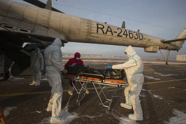 Medical workers transport a patient suspected of having coronavirus from an ambulance helicopter to a hospital outside Ulan-Ude, the capital of the Russian region of Buryatia, on Friday, December 11, 2020. Russia has recorded more than 2.7 million cases of COVID-19, and over 48,000 deaths. (Photo by Anna Ogorodnik/AP Photo)