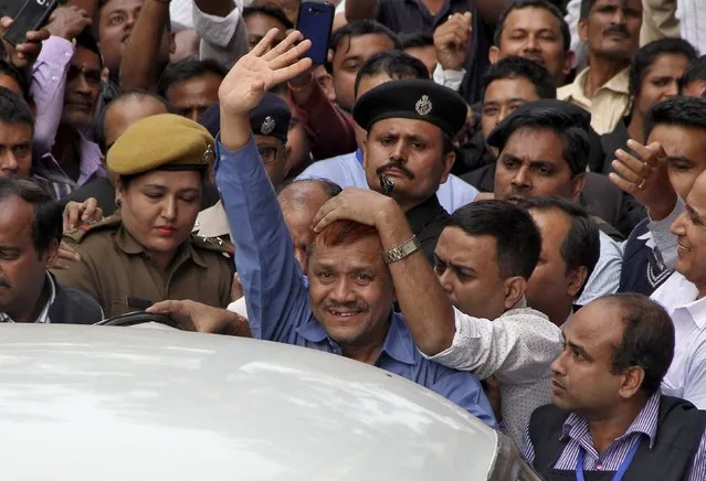 Anup Chetia waves to the media outside a court in Guwahati, India, November 18, 2015. Bangladesh handed Chetia, the founder of militant separatist group United Liberation Front of Asom (ULFA), to India last week, a rebel leader that for years New Delhi had fought to extradite. (Photo by Utpal Baruah/Reuters)