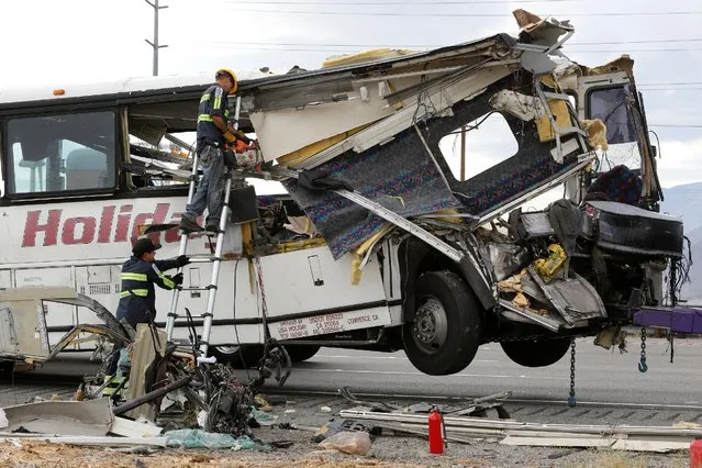 Workers cut away debris from the front of a bus involved in a mass casualty crash on the westbound Interstate 10 freeway near Palm Springs, California October 23, 2016. (Photo by Sam Mircovich/Reuters)