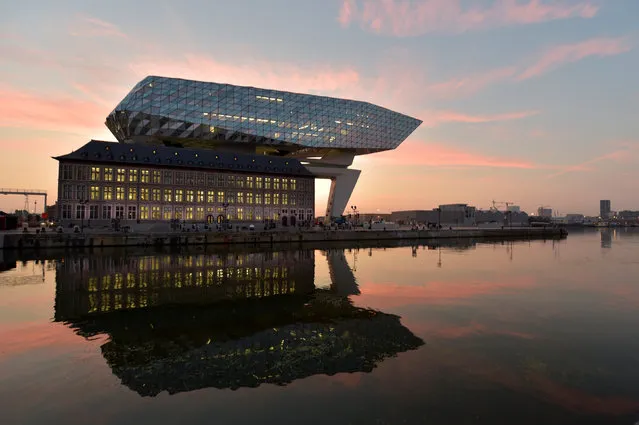 The sun rises behind the new headquarters for the Antwerp Port Authority on the Kattendijk dock, the Port House, a monumental design by Zaha Hadid Architects in Antwerp, Belgium September 22, 2016. (Photo by Eric Vidal/Reuters)