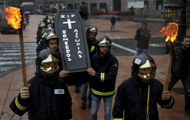 Firefighters take part in a protest in front of the regional parliament of Asturias to demand better organization and more staff in Oviedo, northern Spain, November 26, 2015. The words on the coffin lid read, "R.I.P, Firefighters of Asturias". (Photo by Eloy Alonso/Reuters)