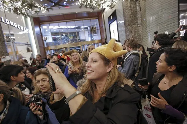 A woman in a turkey hat takes a photo as she enters Macy's Herald Square store during the early opening of the Black Friday sales in the Manhattan borough of New York, November 26, 2015. (Photo by Andrew Kelly/Reuters)