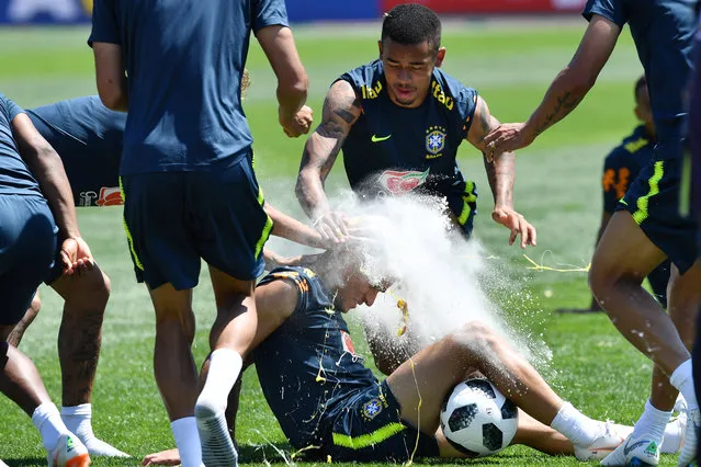 Brazil's Neymar (not in frame) and Gabriel Jesus (C) break an egg on the head of teammate Philippe Coutinho as they celebrate his birthday during a training session at Sochi Municipal Stadium in Sochi on June 12, 2018, ahead of the Russia 2018 World Cup football tournament. (Photo by Nelson Almeida/AFP Photo)