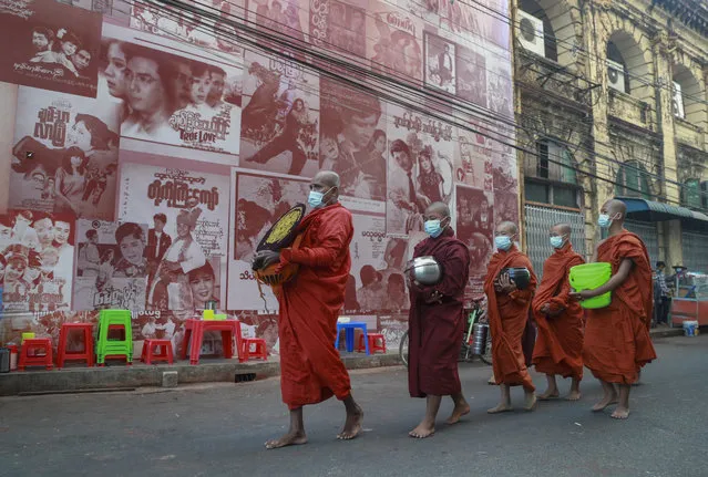 Buddhist monks walk begging for alms in Yangon, Myanmar, Tuesday, February 2, 2021. (Photo by Thein Zaw/AP Photo)