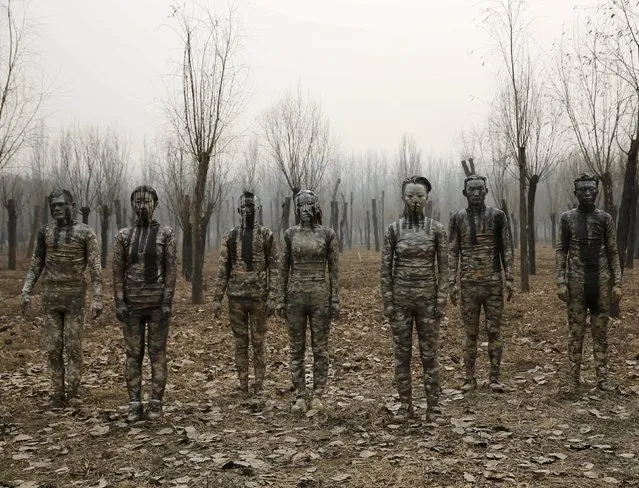 Models painted in camouflage colours to blend in with the background pose for Chinese artist Liu Bolin's artwork “Dongji”, or Winter Solstice, on the second day after China's capital Beijing issued its second ever “red alert” for air pollution, in Beijing, China, December 20, 2015. (Photo by Kim Kyung-Hoon/Reuters)