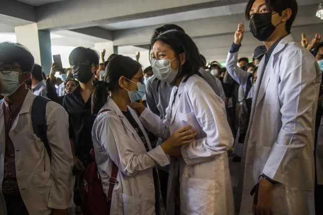 Fellow medical students grieve as others flash three-fingered salute during the funeral of Khant Ngar Hein in Yangon, Myanmar Tuesday, March 16, 2021. Khant Ngar Hein, a 18-year old student of medicine was shot on his chest on Sunday, March 14 in Tamwe, Yangon by security forces during an anti-crop protest. (Photo by AP Photo/Stringer)