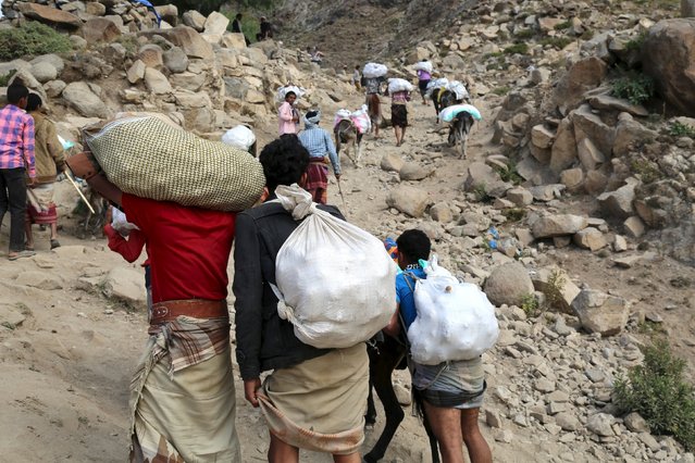 People carry foodstuff and goods as they transport them on a mountainous road to Yemen's southwestern war-torn city of Taiz December 26, 2015. (Photo by Reuters/Stringer)