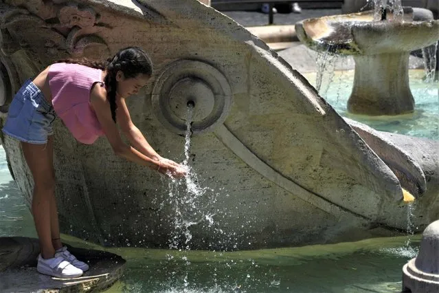 A child refreshes at the Barcaccia fountain of Rome's Spanish Steps, July 10, 2023. Scientists say crushing temperatures that blanketed Europe last summer may have led to more than 61,000 heat-related deaths, highlighting the need for governments to address the health impacts of global warming. (Photo by Gregorio Borgia/AP Photo)