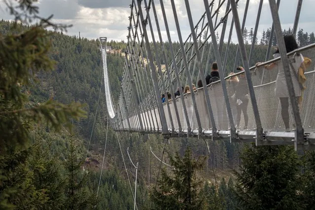 Visitors walk on the Sky Bridge 721, the world's longest suspension pedestrian bridge in Dolni Morava, Czech Republic on May 9, 2022. Sky Bridge 721, the longest pedestrian bridge in the world with a length of 721 meters and an elevation of 95 meters above the ground, is located in the Pardubice region (a break between the Eagle Mountains and the Jesenice). (Photo by Lukas Kabon/Anadolu Agency via Getty Images)
