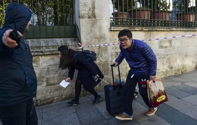 Tourists leave Sultanahmet near the site of a blast in Istanbul's tourist hub of Sultanahmet on January 12, 2016. At least 10 people were killed and 15 wounded in a suspected terrorist attack in the main tourist hub of Turkey's largest city Istanbul, officials said. A powerful blast rocked the Sultanahmet neighbourhood which is home to Istanbul's biggest concentration of monuments and and is visited by tens of thousands of tourists every day. (Photo by Bulent Kilic/AFP Photo)