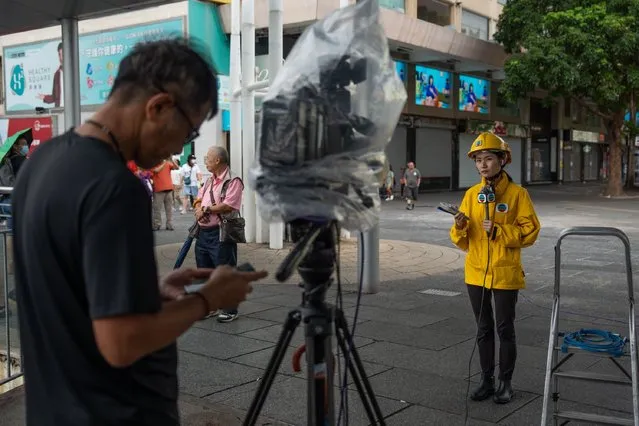 A TV reporter (R) works during Typhoon Saola in Tsim Sha Tsui, Hong Kong, China, 01 September 2023. The No.8 typhoon warning was raised on the morning of 01 September as Typhoon Saola arrived in Hong Kong. The stock market was closed and schools suspended in the city in response to the typhoon. (Photo by Bertha Wang/EPA/EFE/Rex Features/Shutterstock)