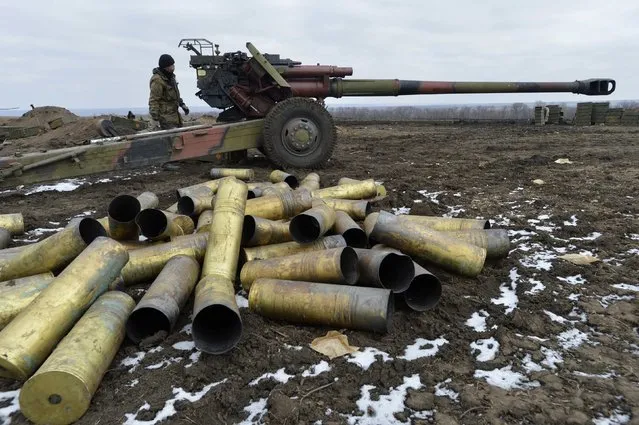 A member of the Ukrainian armed forces stands near a cannon, with shell cases seen in the foreground, at positions in Donetsk region, eastern Ukraine, February 20, 2015. REUTERS/Oleksandr Klymenko (UKRAINE - Tags: MILITARY POLITICS CONFLICT)