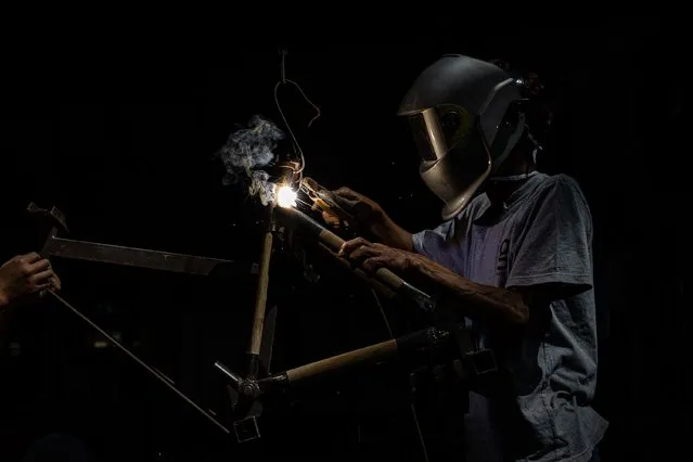 A worker welds Spedagi frame at Piranti Works workshop on June 02, 2021 in Temanggung, Indonesia. The Spedagi Bamboo Bike takes advantage of the light weight and durability of bamboo. It has the best vibration dampening characteristics for a bike and local materials are easy to get as bamboo grows very fast. The bike design uses giant bamboo (Dendrocalamus asper) for its abundance in the local area around the village, its large diameter, and its thick walls which makes it possible to create bicycle frame tubes of a uniform size. Singgih Susilo Kartono, Spedagi’s creator, hopes not only to build a unique bike that uses natural materials, but to start a revitalization movement that he hopes will empower the village as a sustainable and self-sufficient community. Spedagi bikes are widely used in France, Japan, and large Indonesian cities such as Jakarta, where cycling is gaining popularity as an alternative to sitting in vehicles for hours on traffic-choked roads. Spedagi won the Bronze Award in Hong Kong DFA Design for Asia Awards 2017, the Japan Good Design Gold Award 2018, Excellent Product Design in German Design Award Special 2019, and has passed the vibration fatigue impact test by the Japan Vehicle Inspection Association (JVIA). (Photo by Robertus Pudyanto/Getty Images)